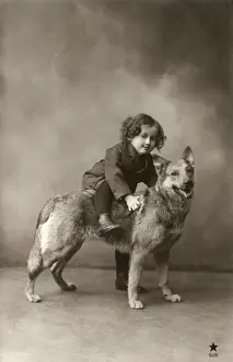 Studio portrait, child sitting on back of dog, France