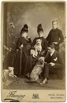 Studio portrait, family of four with three terrier dogs