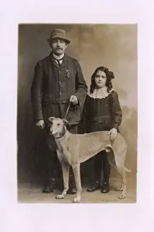 Studio portrait, father and daughter with greyhound