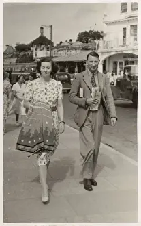 Stylish couple on holiday in Paignton walk along seafront