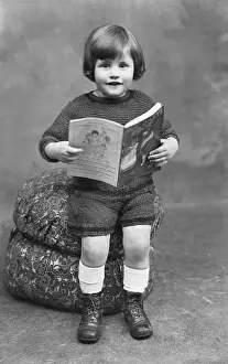 Sweet little boy reading a childrens magazine