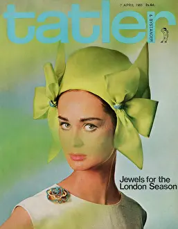 Tatler Front Cover - A woman looking at the camera wearing a green hat with bows on each side, pink lipstick, and a blue diamond brooch