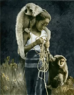 Thai woman accompanied by two gibbons