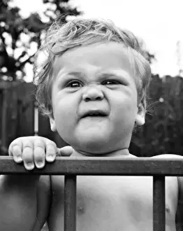 Toddler in a playpen in a garden