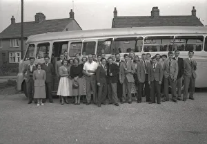 A Tour party pose next to their Coach
