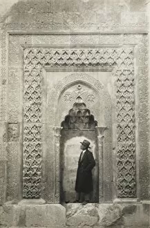A tourist before an elaborate Turkish carved alcove