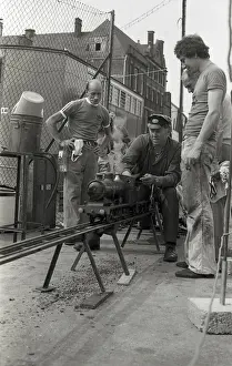 Train driver prepares engine on model steam train