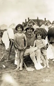 Candid Prints: A truly delightful candid seaside photograph of a Mother and her two young daughters on a sandy beach