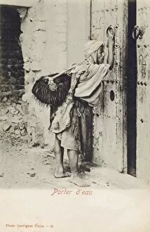 Tunisia, Water Carrier knocking at an impressive wooden door