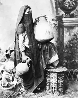 Veiled woman with pots, Egypt