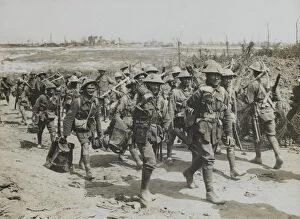 Vickers machine-gun team marching past a working party