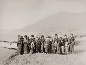 Vintage 19th century photograph: group of children on a shore in front of a fishing boat