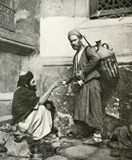 Water carrier handing a drink to seated man, Egypt