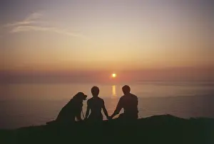 Seascape Prints: West Country sunset with couple and dog