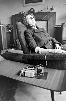 Snoring Prints: Woman asleep in an armchair with an anti-snoring machine attached to her
