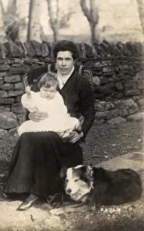 Woman and baby with a dog in a garden