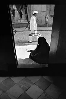 A woman beggar sits in a church doorway, Cadiz, Spain