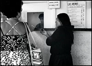 Woman begging at kiosk window, Valencia, Spain