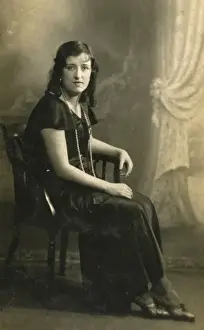 Woman in black dress and pearls