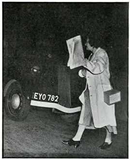 Precaution Prints: Woman crossing road in the dark in white coat, Sept 1939