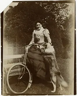 Woman with dog and bicycle in a garden