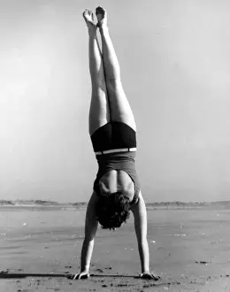 Swimwear Prints: Woman doing handstand on beach