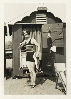 Swim Collection: Woman drying herself after a dip in the sea outside her hut
