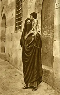 Woman in face veil with child on her shoulder, Cairo, Egypt