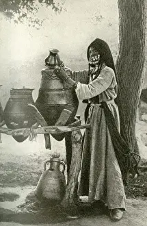 Refreshment Prints: Woman in face veil drawing water from a jar, Egypt