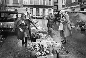 Rainy Collection: A woman flower seller in a Paris street market