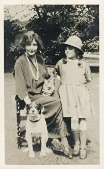 Woman and girl with dog and cat in a garden