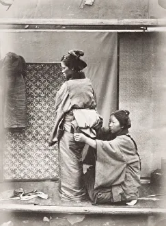 Woman having the obi sash tied over her kimono, Japan