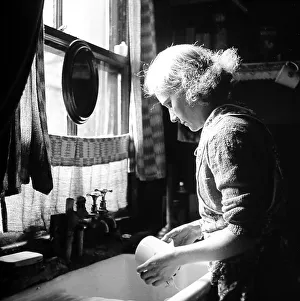 Dishes Prints: Woman at kitchen sink washing dishes, 1920s 0r 1930s