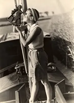 Woman looks through sextant on board a boat