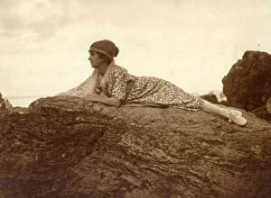 Images Dated 31st October 2018: Woman lying on a rock at the seaside