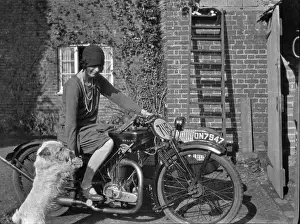 Woman on a motorbike with a dog
