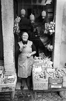 Shopkeeper Prints: Woman outside fruit shop Lisbon