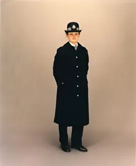 Woman police officer in coat and bowler hat, London
