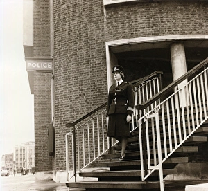 Woman police officer leaving police station, London