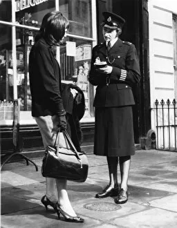 Woman police officer and woman with handbag, London
