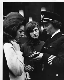 Woman police officer and two young women, London