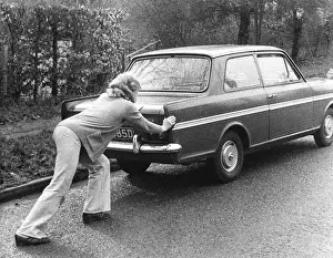Problems Prints: Woman pushing a car along a road