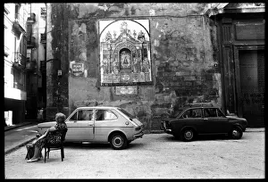 Woman resting on chair outside church, Valencia, Spain
