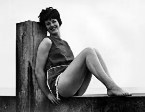 Images Dated 18th November 2016: Woman at the seaside, leaning on a wooden post