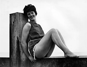 Images Dated 18th November 2016: Woman at the seaside, leaning on a wooden post