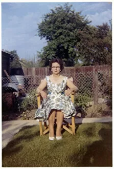 Images Dated 3rd February 2021: Woman sitting in garden chair - neat suburban garden