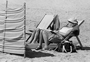 Images Dated 13th June 2019: Woman sleeping on deck chair on Tenby Beach, Wales