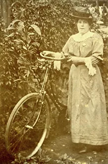 Woman standing in a garden with her bicycle