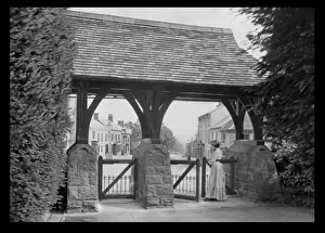 Roofed Prints: Woman standing at a roofed gate