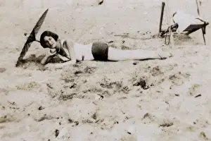 Sunshade Prints: Woman sunbathing underneath a parasol on the beach